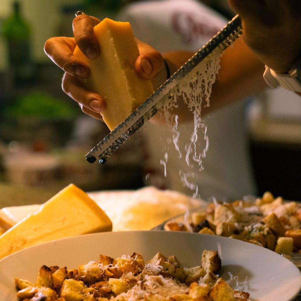 grating cheese on pasta for guests at a launch party in dubai