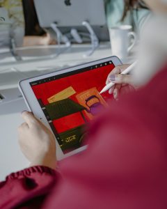 lady working on branding in a social media marketing agency, for an indian restaurant in dubai using an apple pencil and an ipad