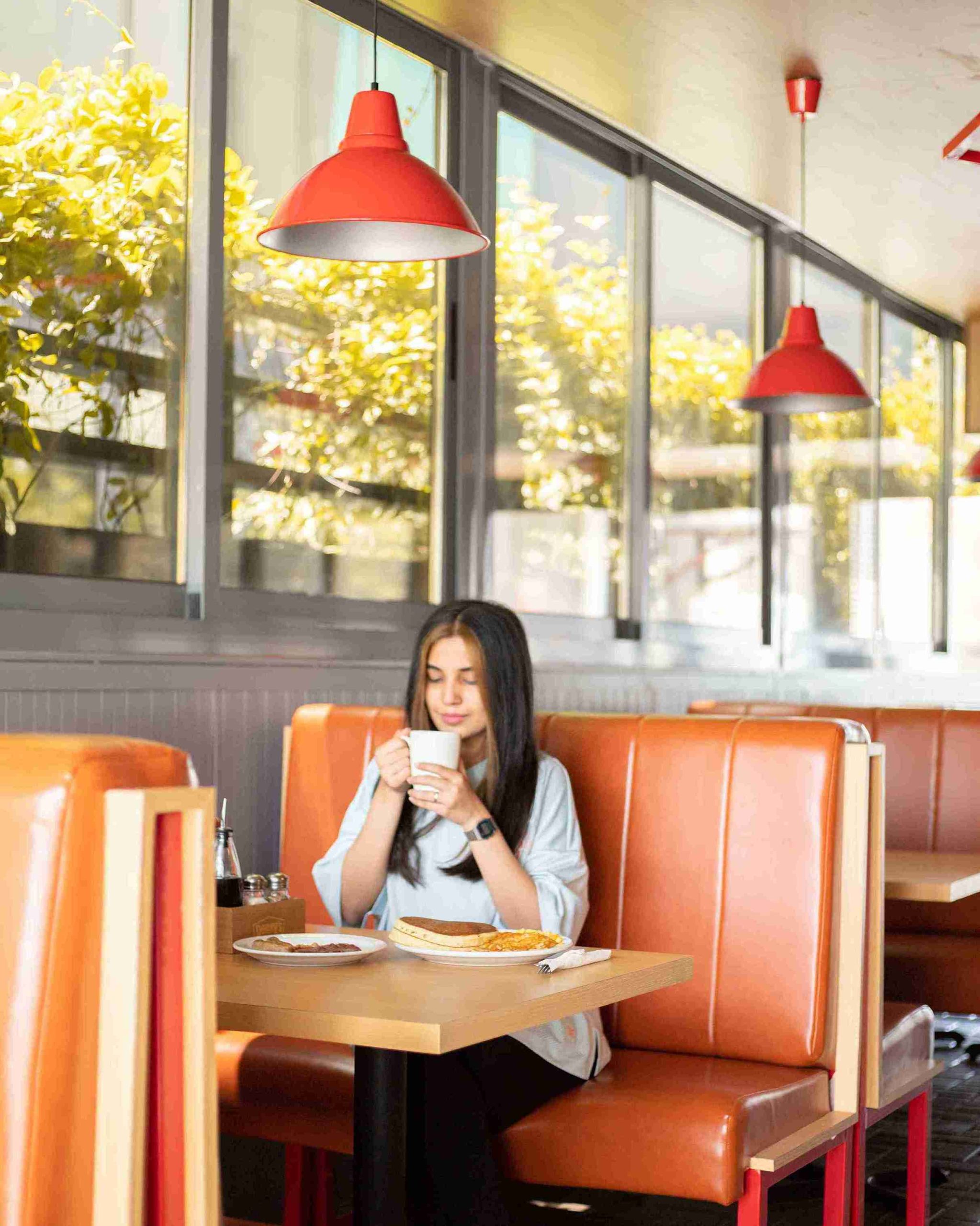 Customer enjoying breakfast in a Denny&rsquo;s booth in Dubai