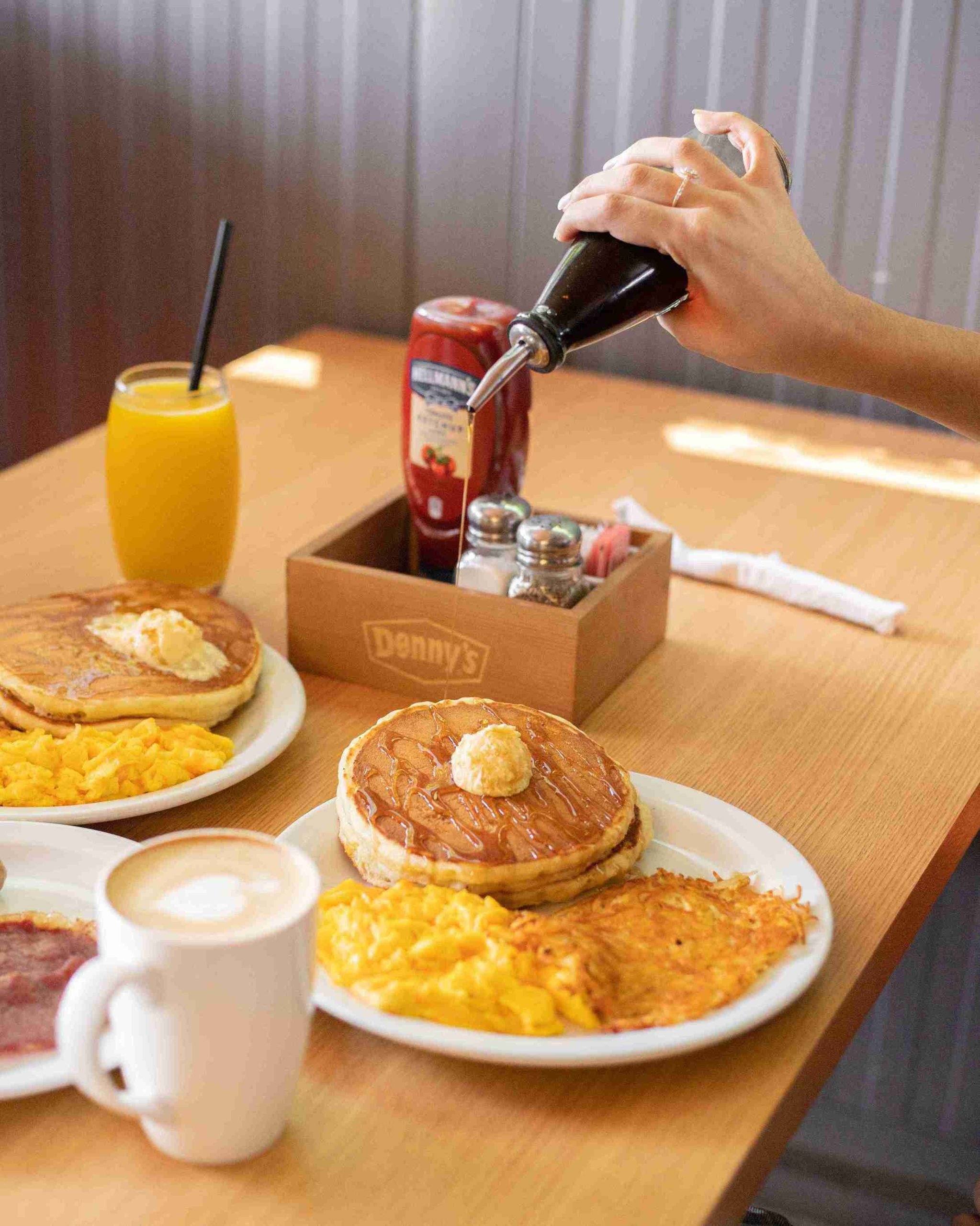 Denny&rsquo;s breakfast spread with pancakes, eggs and coffee