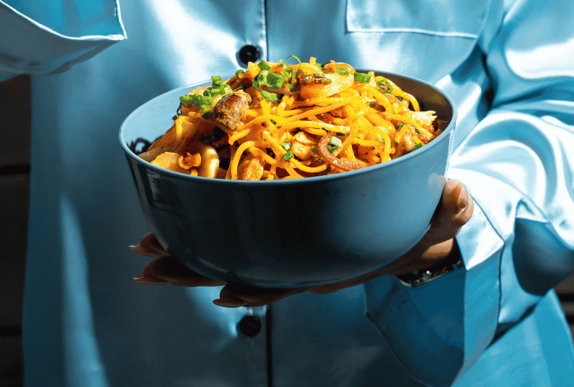 Mmmbox noodle bowl held in two hands